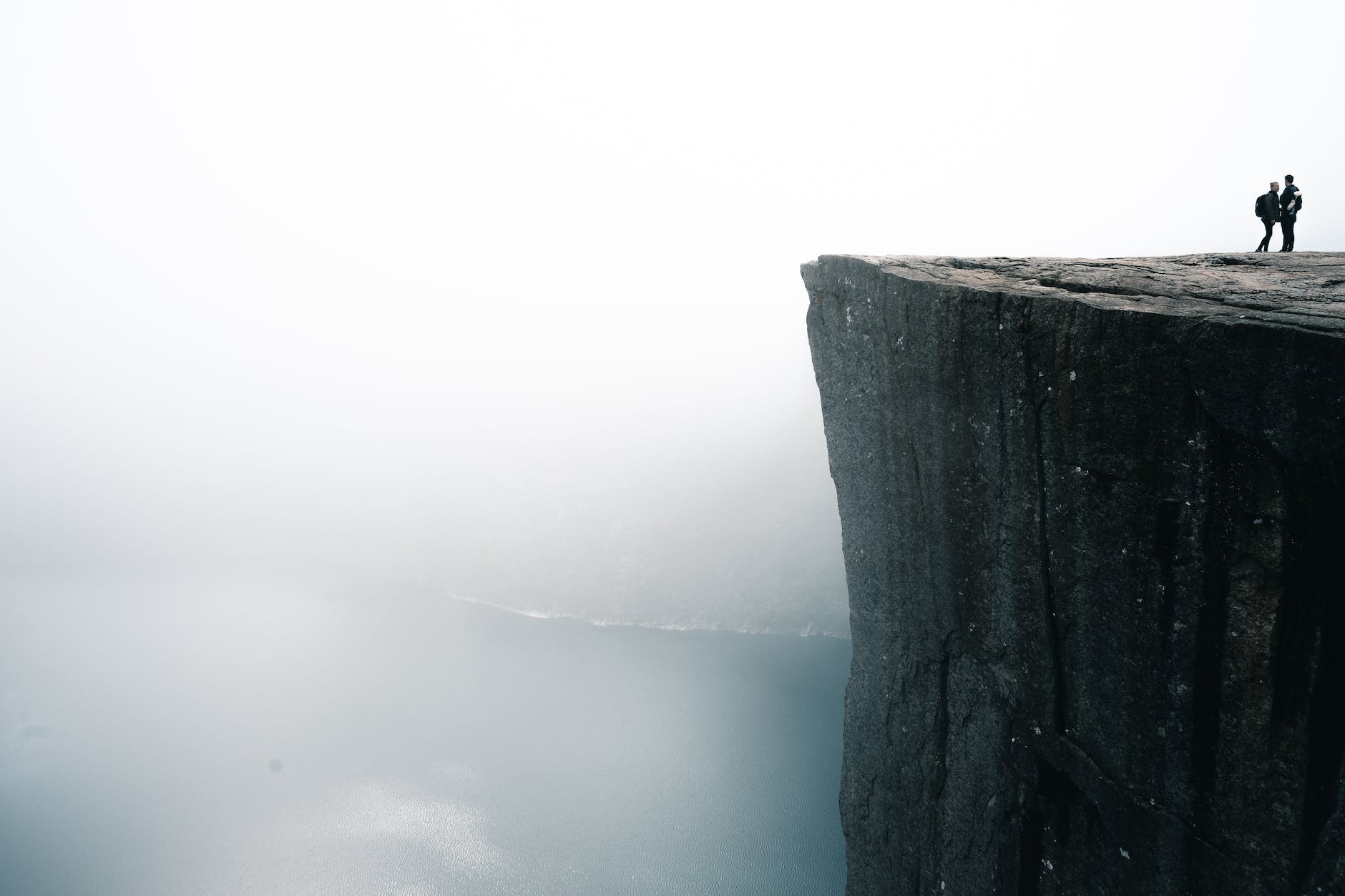two people standing on cliff