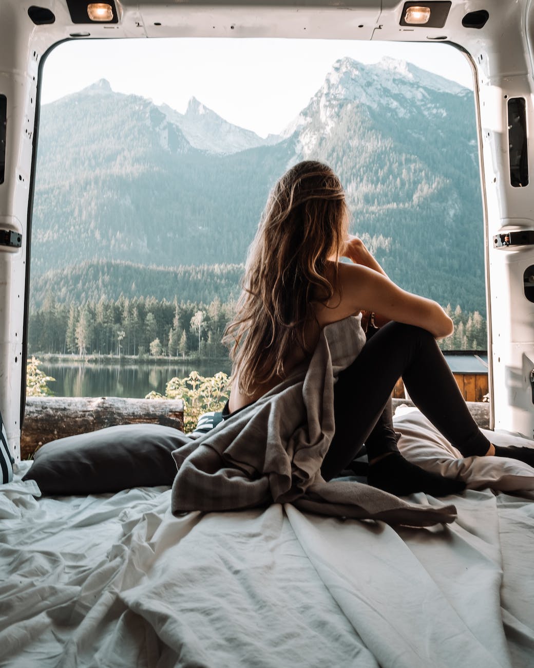 woman in the back of a van looking at mountains