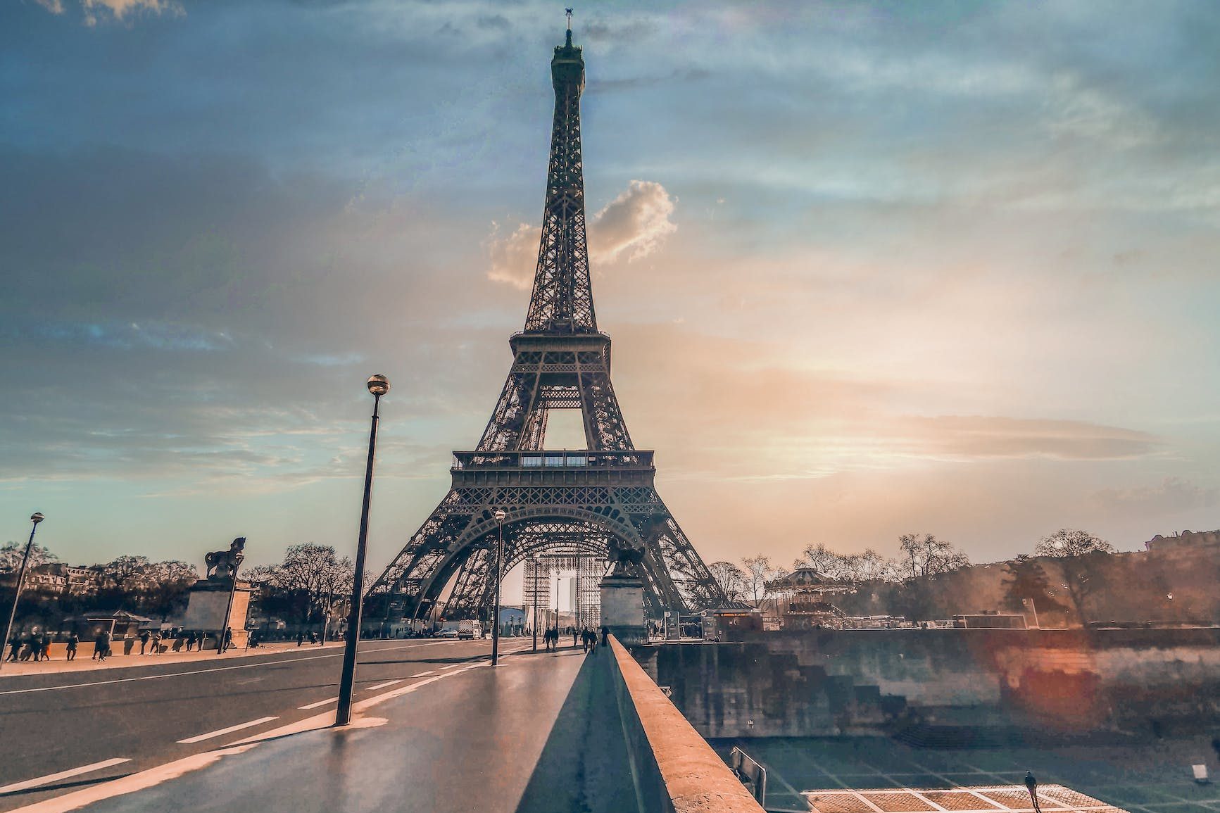 eiffel tower near city road under sky at sunset